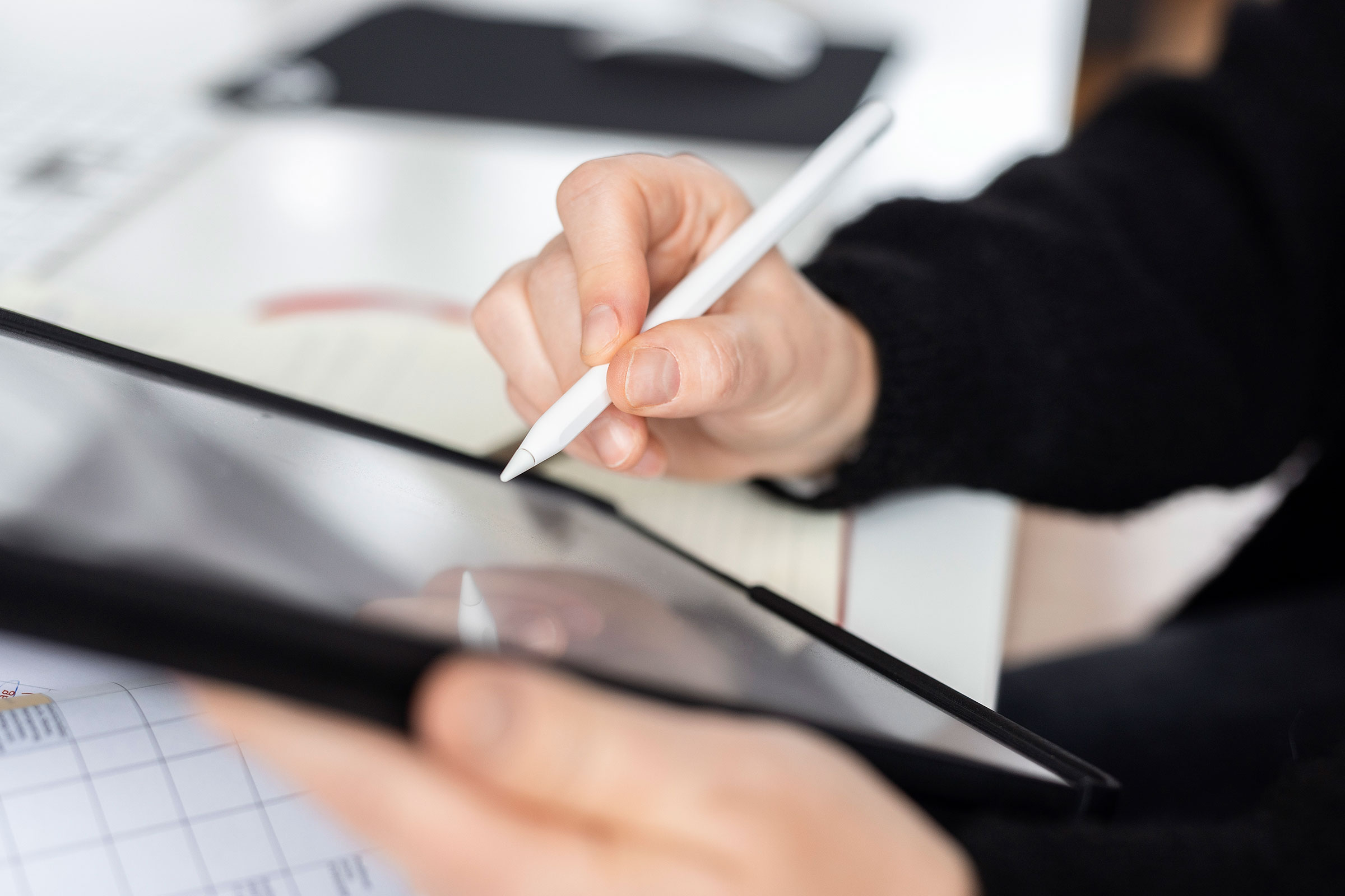 Arbeitssituation in der Agentur, eine Person zeichnet mit einem Stift auf einem Tablet